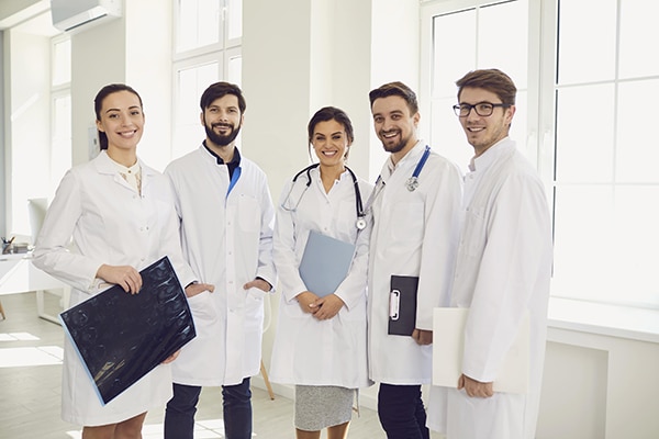 Group of doctors standing and smiling while facing the camera